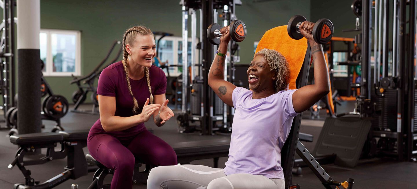 Older woman doing shoulder presses while getting motivated